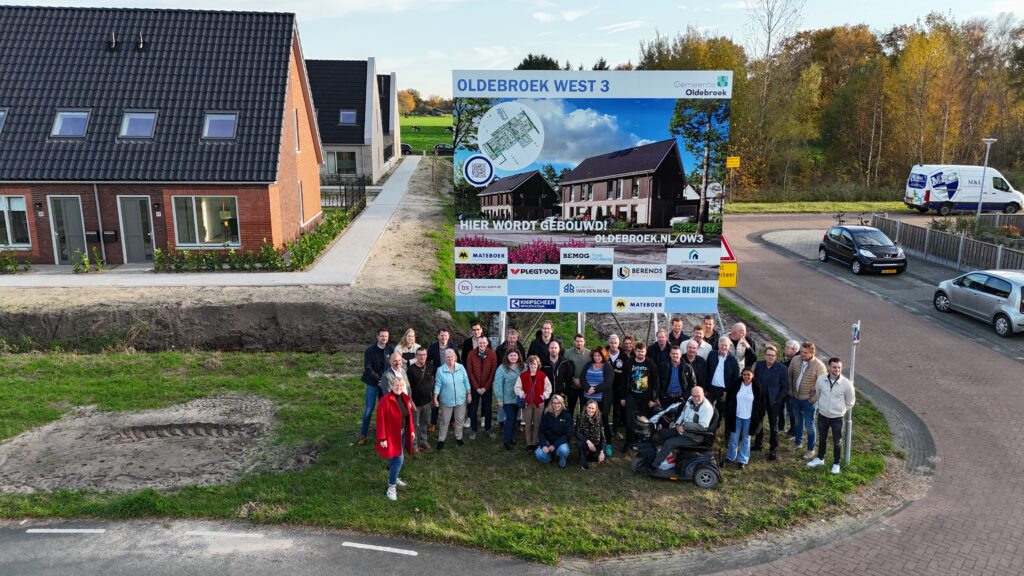 De nieuwe huurders van Oldebroek West III staan op de foto bij het bouwbord met de gemeente Oldebroek, Omnia Wonen en andere partners